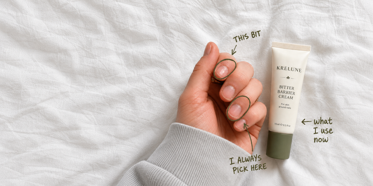 Krelune Bitter Barrier Cream beside a hand, with green notes marking the skin around the nails.